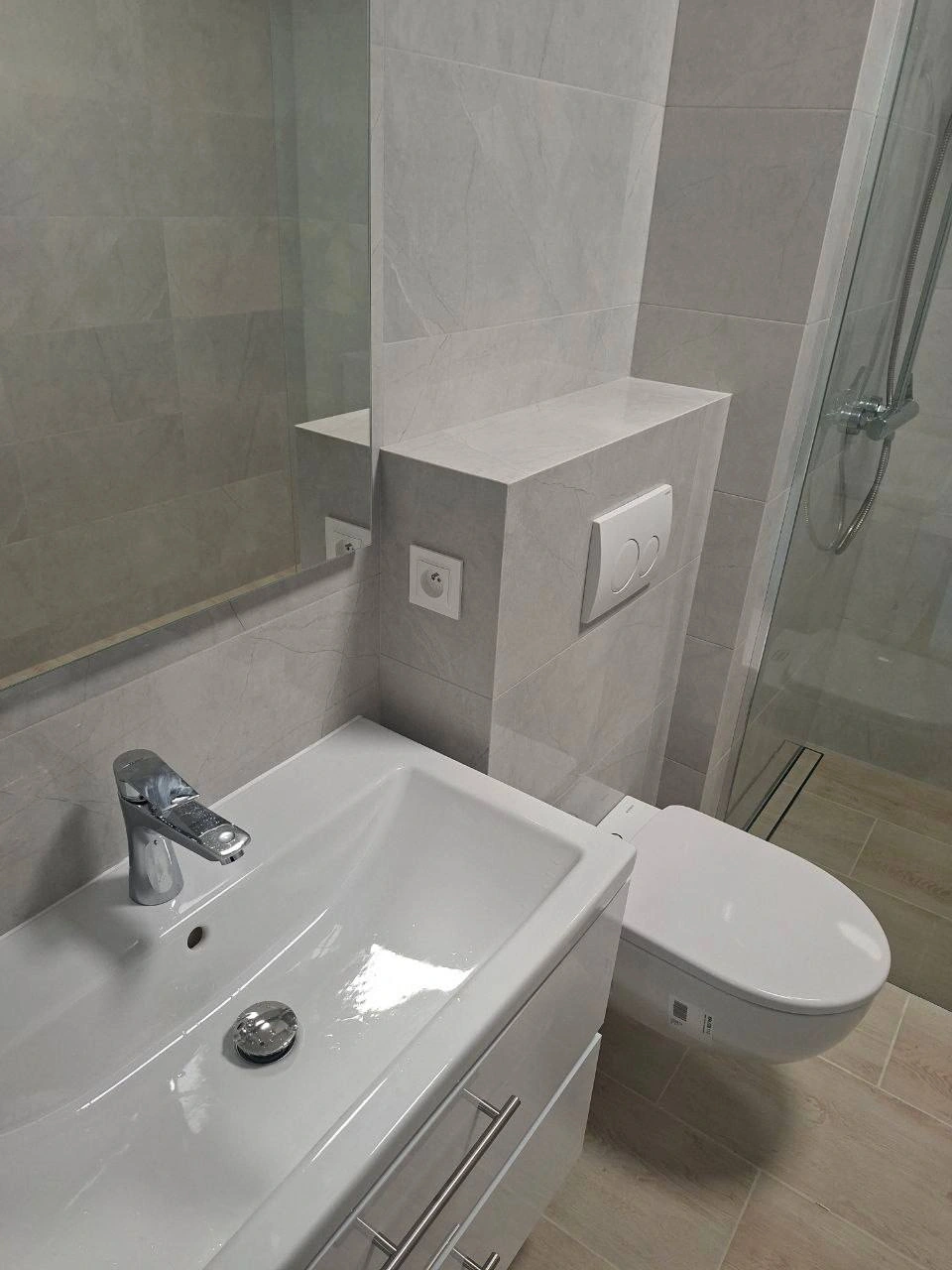 Zabudowa stelaża WC i detale przy umywalce.